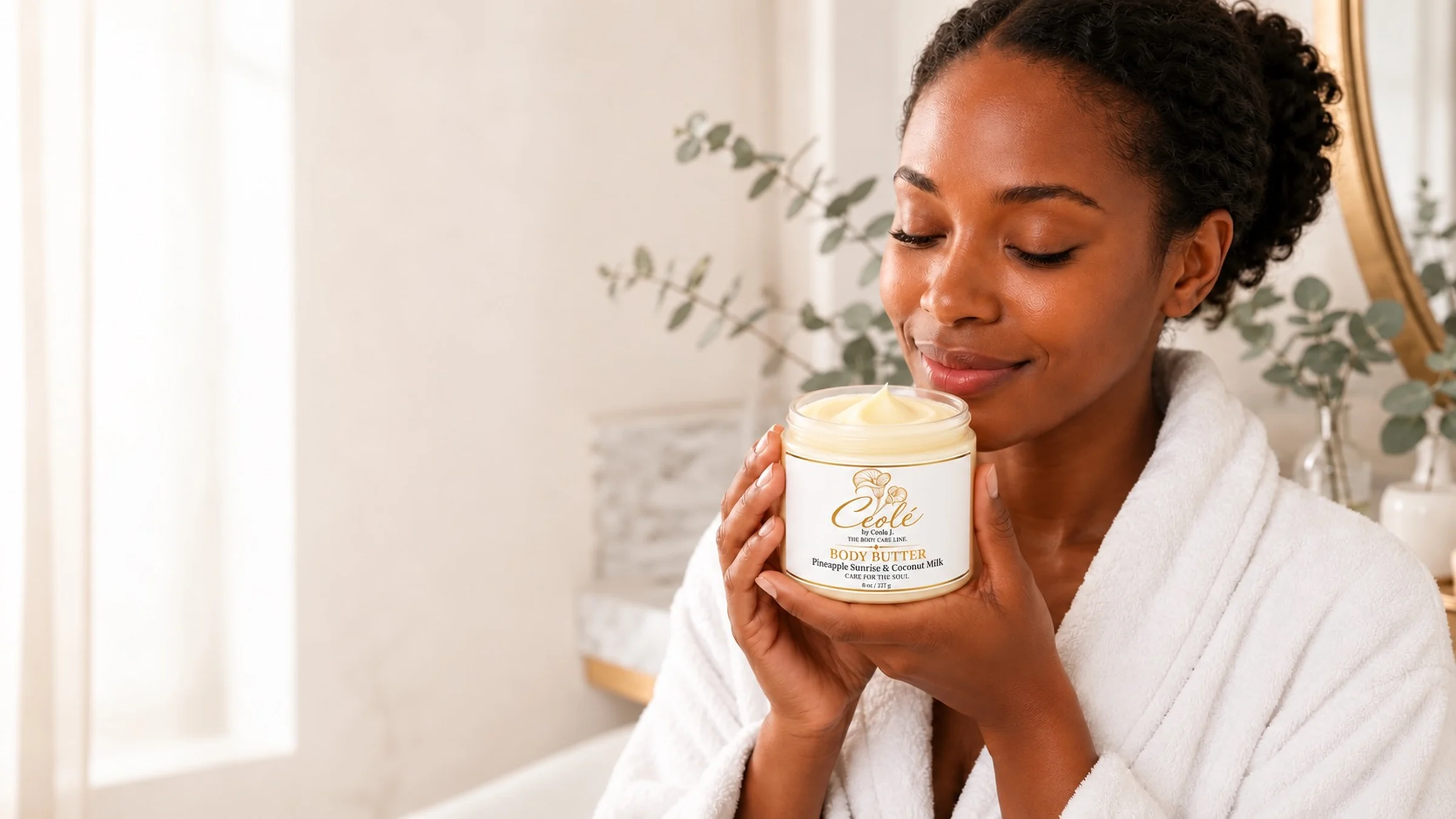 Ceolé Pineapple Sunrise & Coconut Milk body butter, open, held by a woman in a spa robe